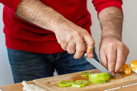 Man in red blouse cooking delicious fruit salad .の写真素材