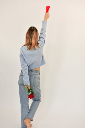 Rear view of a beautiful casual woman with her hands up . Copy space.の写真素材