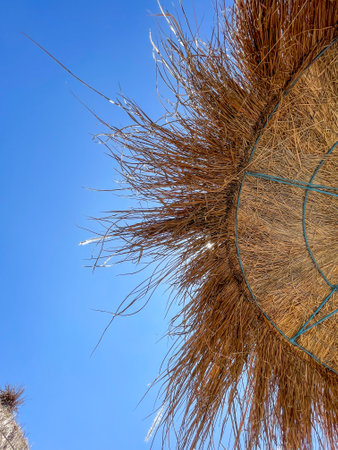 Straw beach umbrella with blue clear sky taken in Albania, Vloreの写真素材