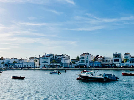 Canal de Tavira . Small boat cruising tranquil green river.