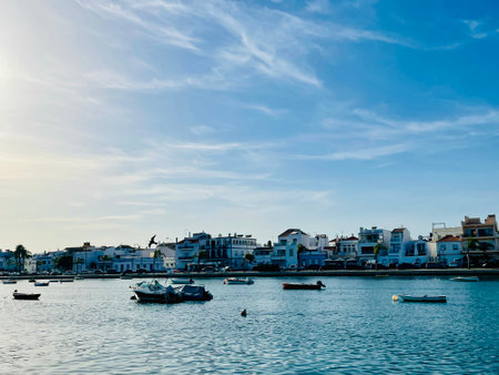 Canal de Tavira . Small boat cruising tranquil green river.の写真素材