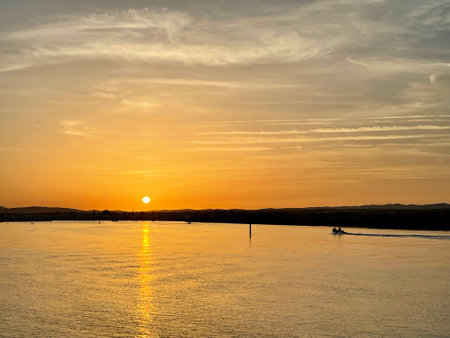 Canal de Tavira . Small boat cruising tranquil green river.の写真素材