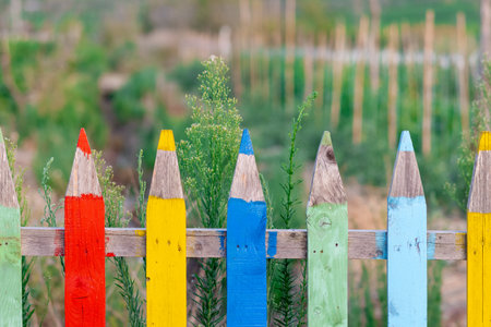 Multi colored fence in the form of large colored pencils. Copy spaceの写真素材