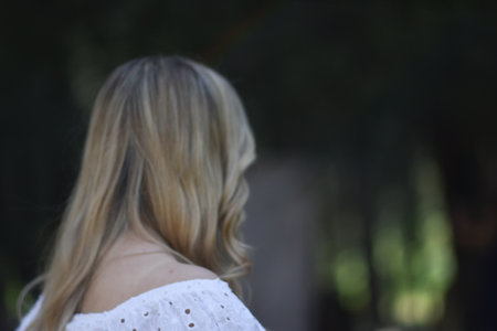 Closeup back view of woman in white hat looking out towards .の写真素材