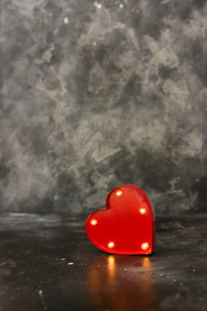 Red lighted heart on a black background. Copy spaceの写真素材