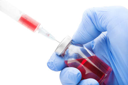 Hand in medical glove picking medication into syringe from the ampouleの写真素材