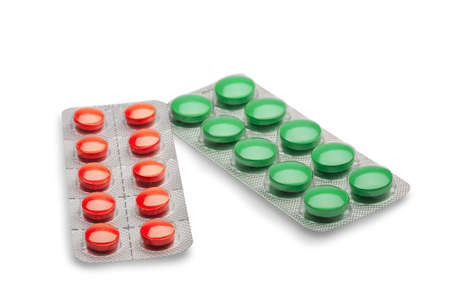 red and yellow pills in plastic silver box on a isolated white backgroundの写真素材
