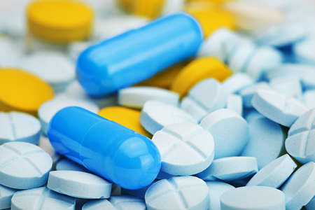 two light blue pills on pile of medical pillsの写真素材