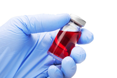 medical glove with  red liquid in tube on isolated background