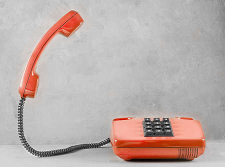 landline red phone on a gray wall backgroundの写真素材