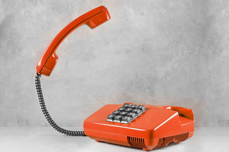 landline red phone on a gray wall backgroundの写真素材