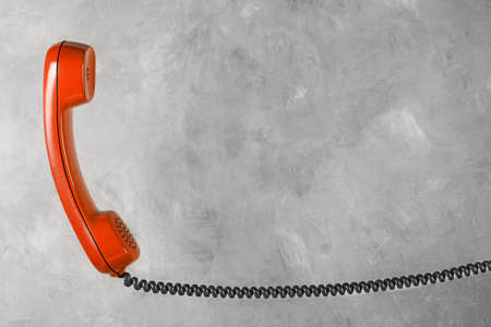 red handset from landline phone on the background wallの写真素材