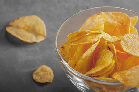 Potato chips in bowl with tomato juice in glassの写真素材