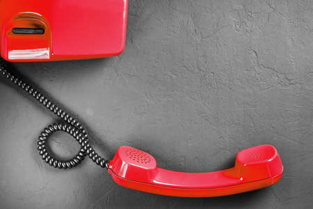 landline red phone on a gray wall backgroundの写真素材