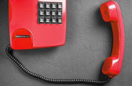 landline red phone on a gray wall backgroundの写真素材