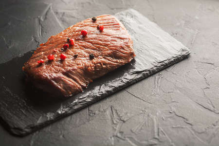 Grilled steak with spices on a black stoneの写真素材