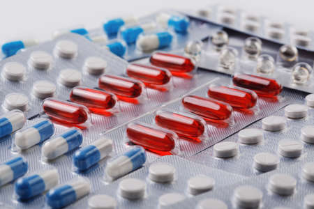 Red vitamin pills in plastic bag with other pillsの写真素材