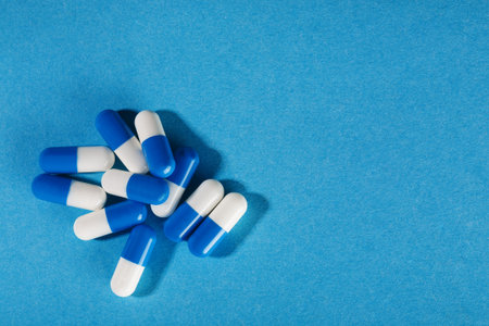 Medical pills of blue and white on a bright background