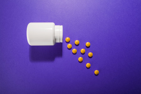 Medical pills vitamins on a colored background with a vialの写真素材