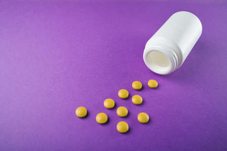 Medical pills vitamins on a colored background with a vialの写真素材