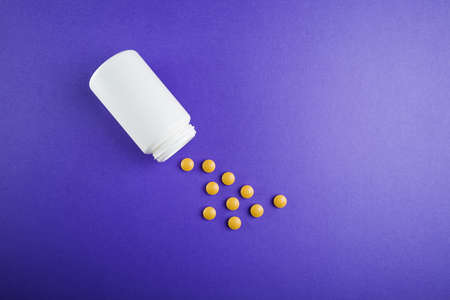 Medical pills vitamins on a colored background with a vialの写真素材