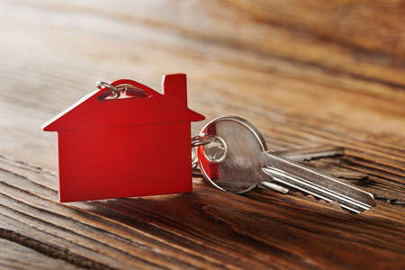 Real estate concept, red keychain with house symbol wooden backgtoundの写真素材