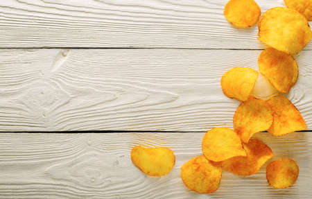 Crispy potato chips in on old kitchen table fastfood concepteの写真素材