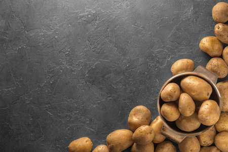Raw potato food. Pile of fresh potatoes lying  on old concrete table. Concept of food background. Free place for text, top view.の写真素材