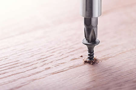 screwdriver screw in a wood oaks plankの写真素材
