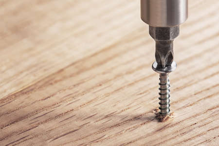 screwdriver screw in a wood oaks plankの写真素材