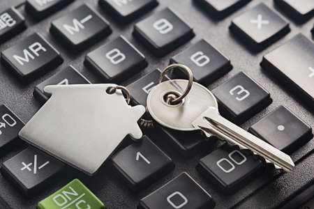 Real estate, keychain with house symbol. Calculator with finance blank.の写真素材