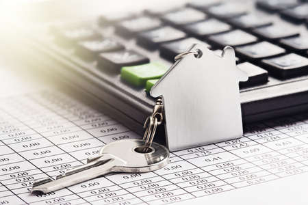 Real estate, keychain with house symbol. Calculator with finance blank.の写真素材