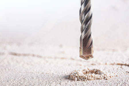 metal drill bit make holes in concrete wall on industrial drilling machine with shavings. Metal work industryの写真素材