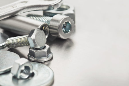 nuts, bolts, screws, washers, bearings on a metal steel background.