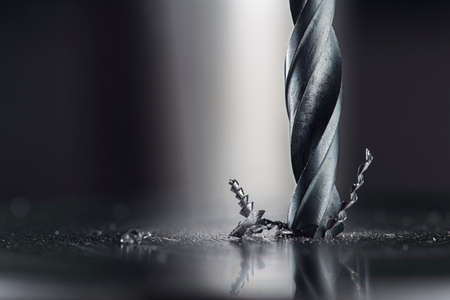 metal drill bit make holes in steel billet on industrial drilling machine. Metal work industry. multi cutting tool and end mill.の写真素材