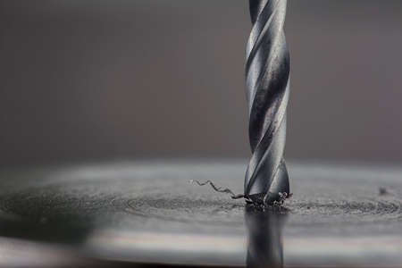 metal drill bit make holes in steel billet on industrial drilling machine. Metal work industry. multi cutting tool and end mill.の写真素材