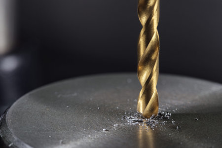 metal drill bit make holes in steel billet on industrial drilling machine. Metal work industry....