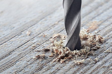 metal drill bit make holes in old wooden plank