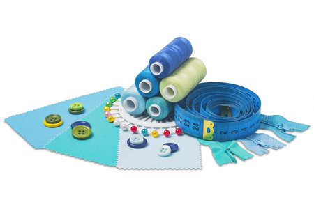 Sewing thread, needle, bobbins, buttons, zipper and fabric samples blue color on isolated white...