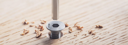 hex bolt screw by hex wrench in wooden oaks plate. Spanner, bolt, screw and nuts.