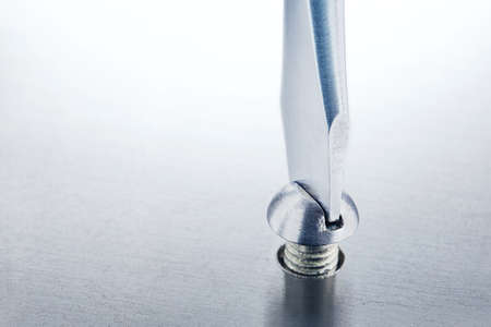 Screwdriver screw in metal steel plate bolt. Spanner, bolt, screw and nuts.の写真素材