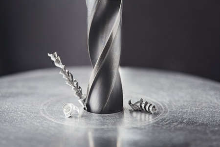 metal drill bit make holes in steel billet on industrial drilling machine. Metal work industry. multi cutting tool and end mill.の写真素材