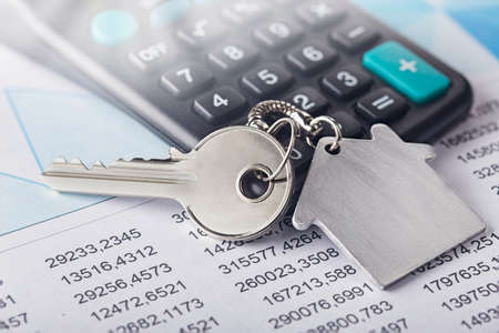 Real estate and investment concept. Calculator with finance blank, keychain with house symbol.の写真素材