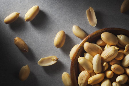 Peanuts in wooden bamboo bowl on concrete background. Nuts.の写真素材