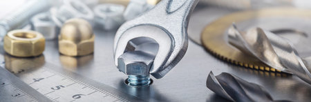 Wrench tightens bolt in steel billet. Spanner, bolt, screw and nuts.