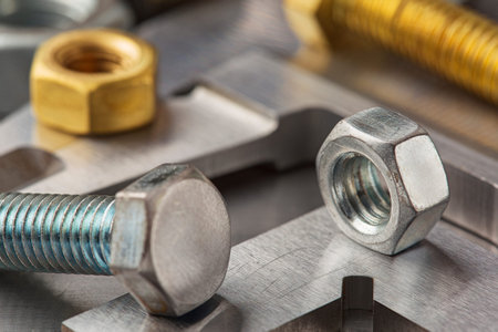 nuts, bolts, screws, washers, bearings on a metal steel background.