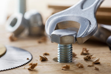 bolt screw by hex wrench in wooden oaks plate with drill bit and circular sawの写真素材