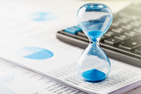 Best time for investment. Hourglass, financial charts and calculator.