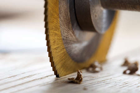 Circular saw cutting wooden plank. Circular milling in oak block.の写真素材