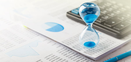 Best time for investment. Hourglass, financial charts and calculator.の写真素材